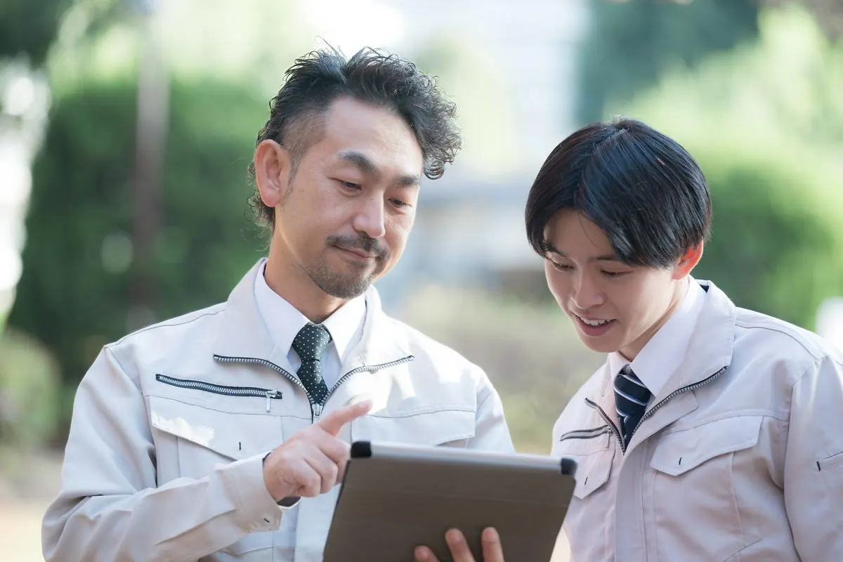 タブレットで同じ数字を確かめる社員
